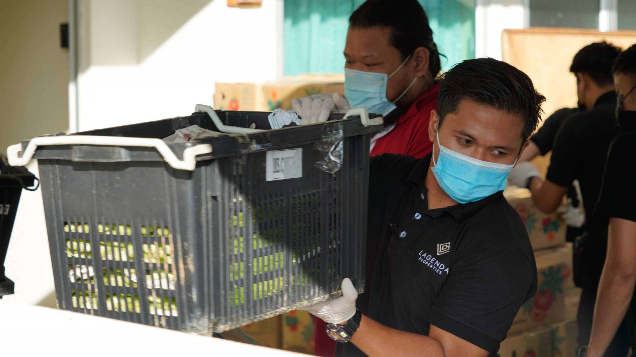 PHOTO – A Lagenda team member handing out food items to BBSAP residents PHOTO - A Lagenda team member handing out food items to BBSAP residents