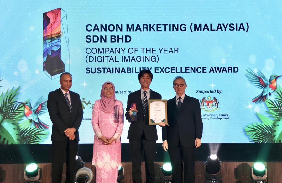 Canon Marketing Malaysia_s President and CEO Masato Yoshiie receiving the Company of The Year award from Deputy Minister of Women, Family and Community Development Datuk S