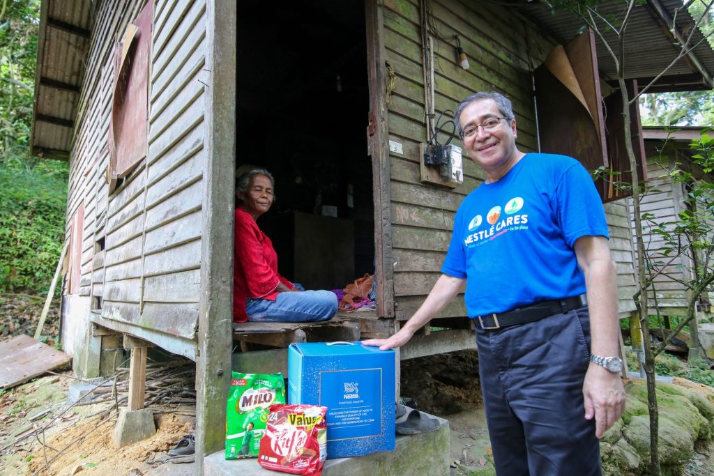 Dato' Adnan Pawanteh, Executive Director of Corporate Affairs at Nestlé Malaysia, sharing a joyful moment during his visit to Kampung Orang Asli Songkok, celebrating the collaborative efforts with EPIC Homes to uplift communities