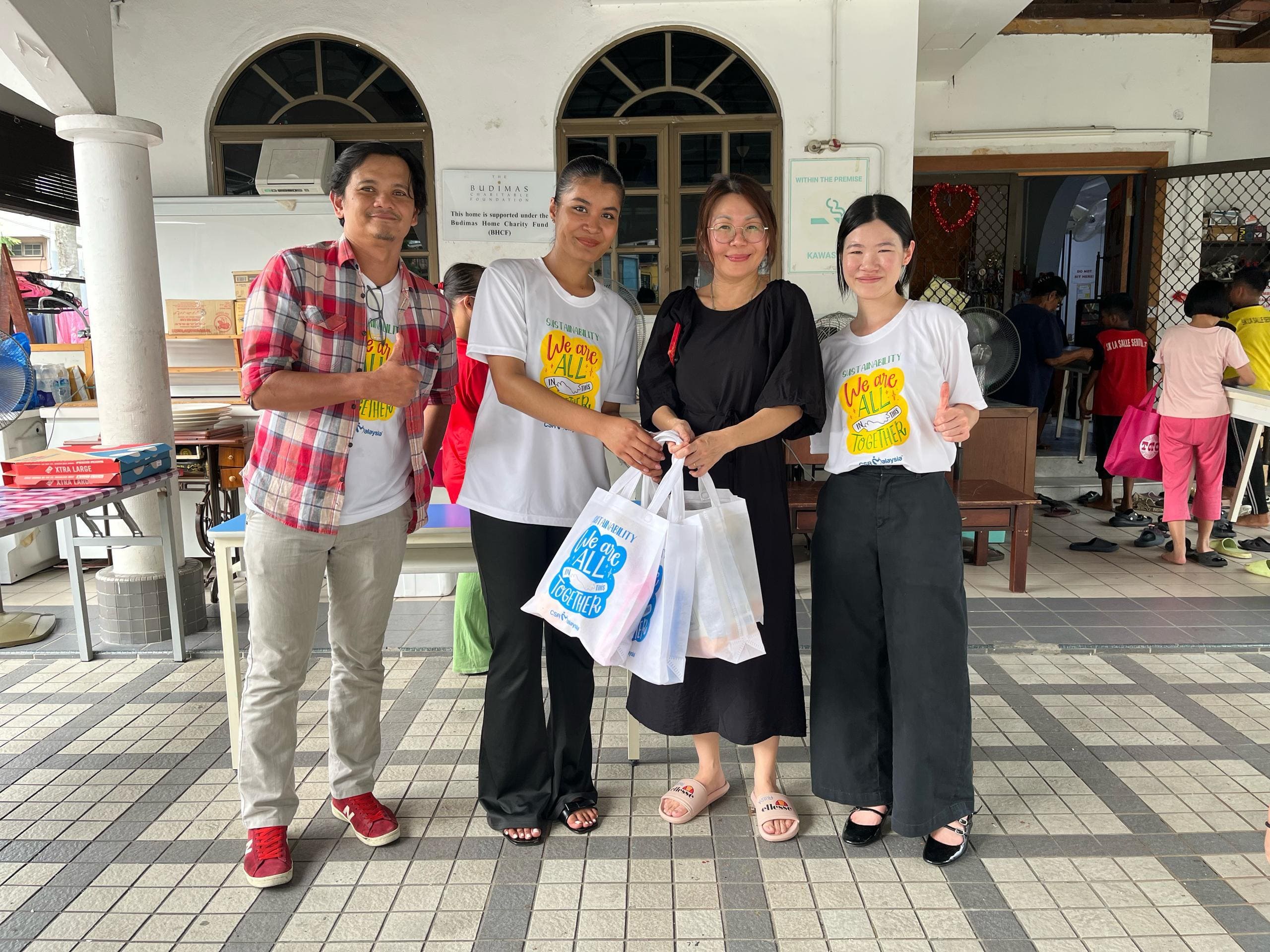 The CSR Malaysia team handing over bags of souvenirs for the children at Hiichiikok Foundation